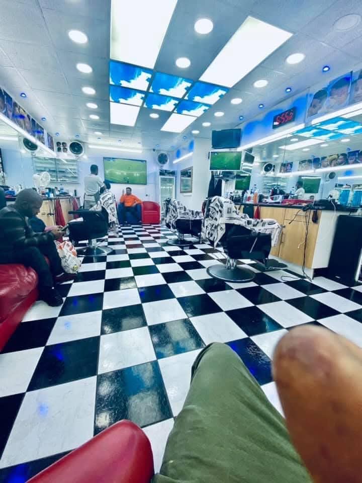 Inside CJ Barbers Shop Ltd — checkered floor, chairs and sky ceiling